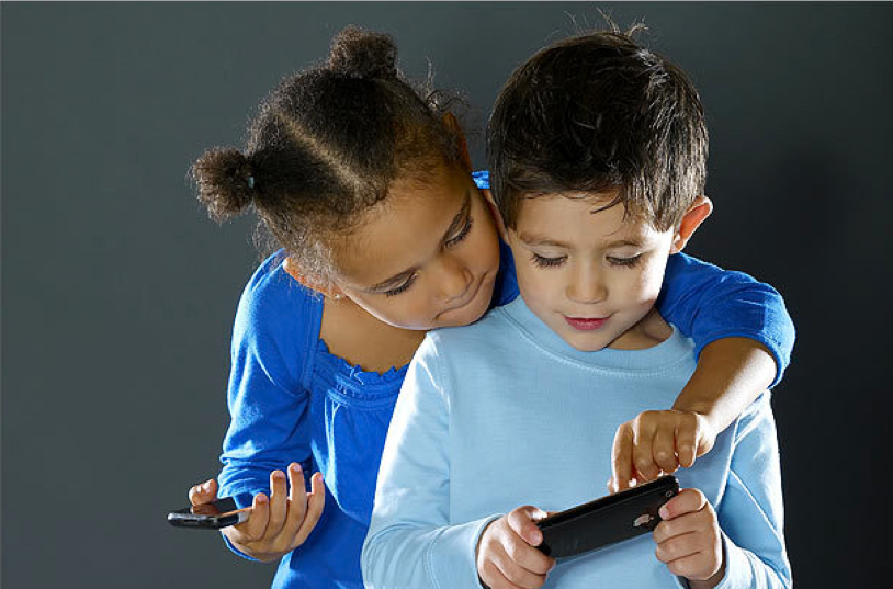 Two kids sharing a tablet, learning together.